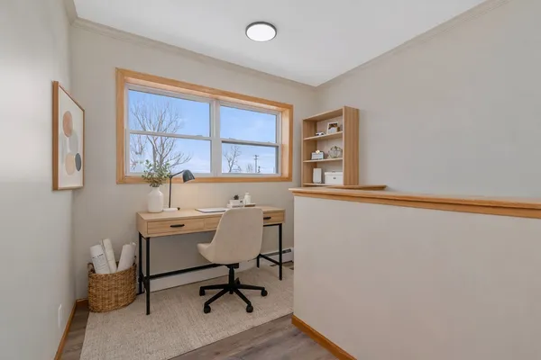 a view of a workspace with furniture and a window