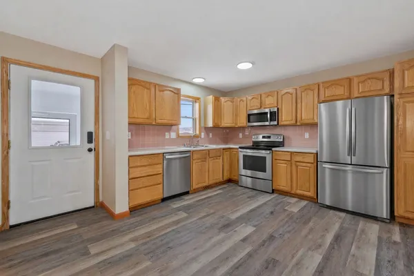a kitchen with a refrigerator a microwave a sink and cabinets
