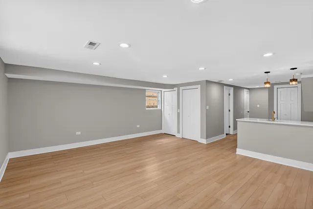 a view of an empty room with wooden floor