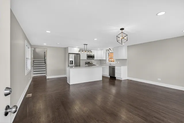 a view of kitchen with wooden floor and electronic appliances