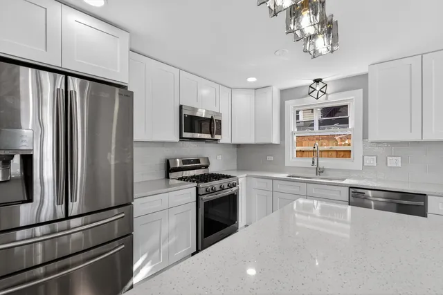 a kitchen with stainless steel appliances a refrigerator sink and microwave