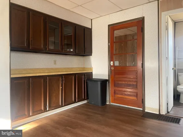a view of a utility room with wooden floor and cabinet