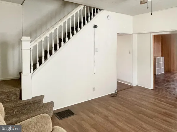 a view of a bedroom with a bed and wooden floor