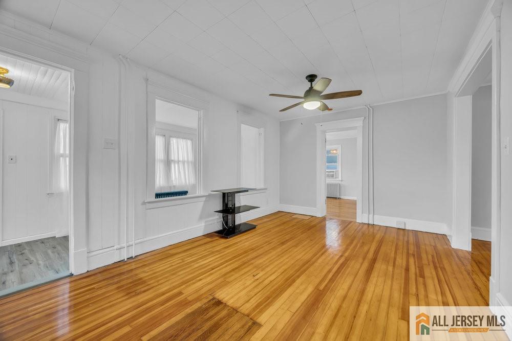 34 Maple Avenue Edison, NJ 08837 - Photo 4 of 20 a view of empty room with wooden floor and fan