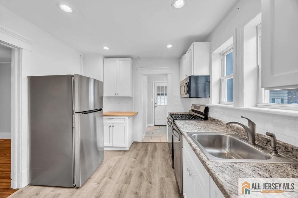 34 Maple Avenue Edison, NJ 08837 - Photo 9 of 20 a kitchen with a refrigerator sink and wooden cabinets