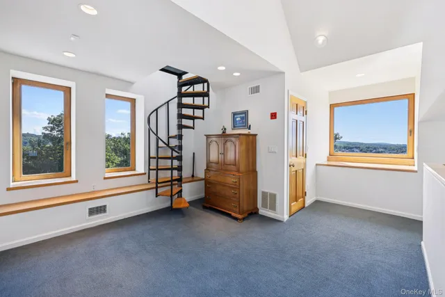 a view of an empty room with window and stairs