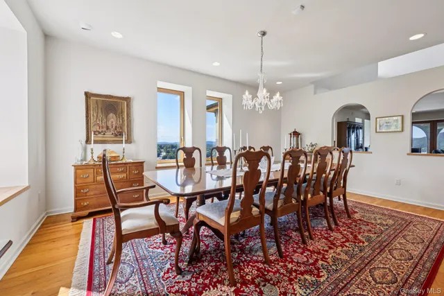 a dining room with furniture a chandelier and wooden floor