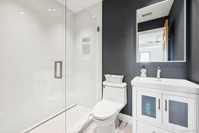 a bathroom with a toilet sink and a mirror