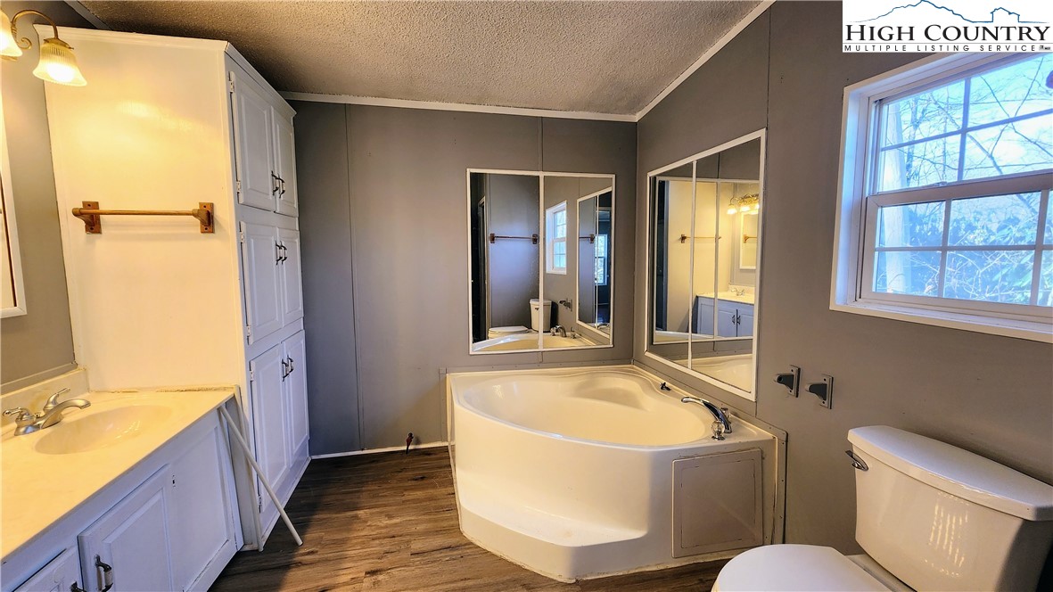 68 Rhoneys View Road Newland, NC 28657 - Photo 22 of 37 a bathroom with a tub a sink and a large mirror