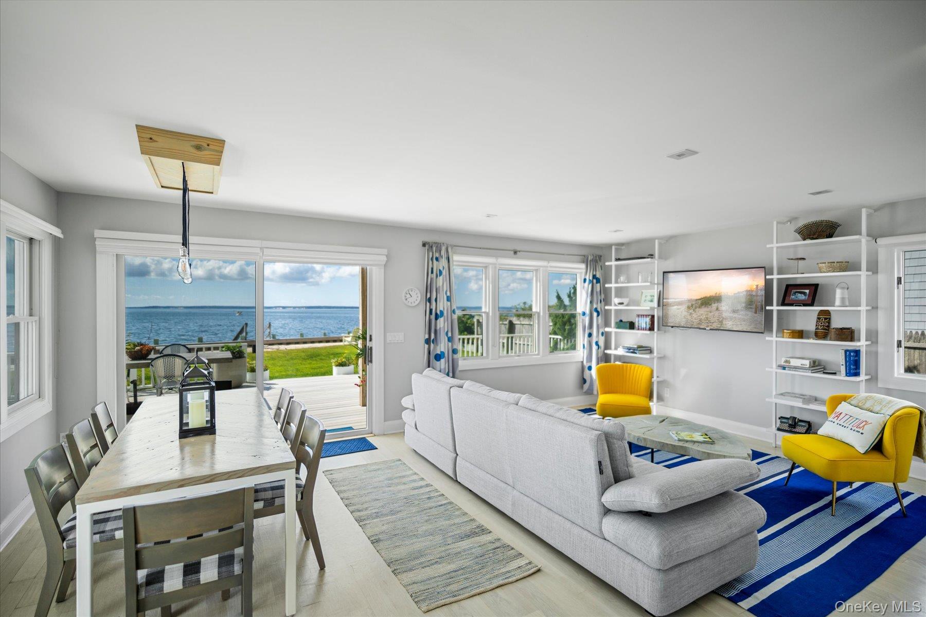4415 Camp Mineola Road Mattituck, NY 11952 - Photo 3 of 44 Sun filled living room with large windows and sliders framing sweeping bay views. Furnishings included in sale.