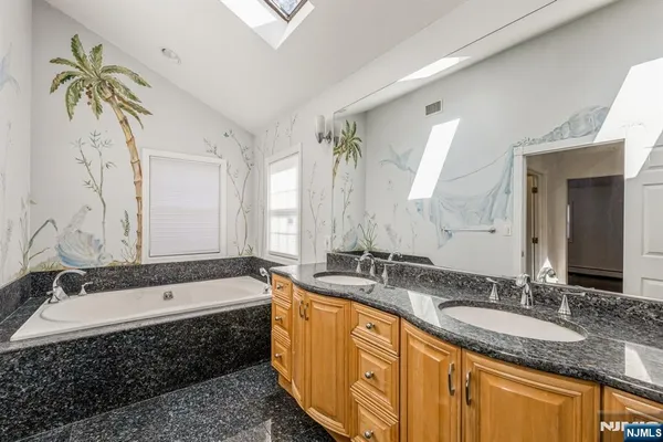 a spacious bathroom with a granite countertop sink mirror and a shower