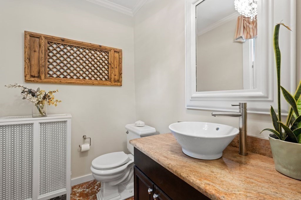 21 Windsor Road Wellesley, MA 02481 - Photo 11 of 28 a bathroom with a granite countertop toilet a sink and a mirror