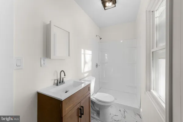a bathroom with a toilet a sink a mirror and vanity
