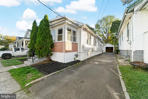 a front view of a house with a yard and potted plants