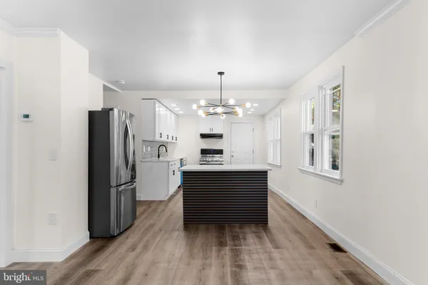 a kitchen with a refrigerator and a stove top oven