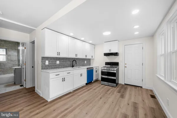 a kitchen with granite countertop a stove top oven and cabinets