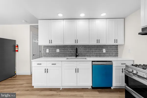 a kitchen with stainless steel appliances granite countertop a stove and a white cabinets