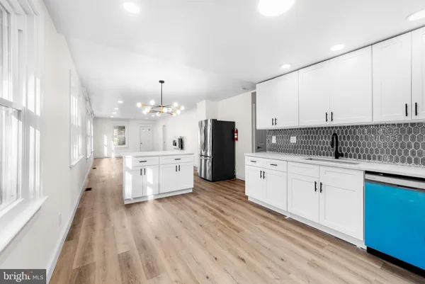 a kitchen with white cabinets and white appliances