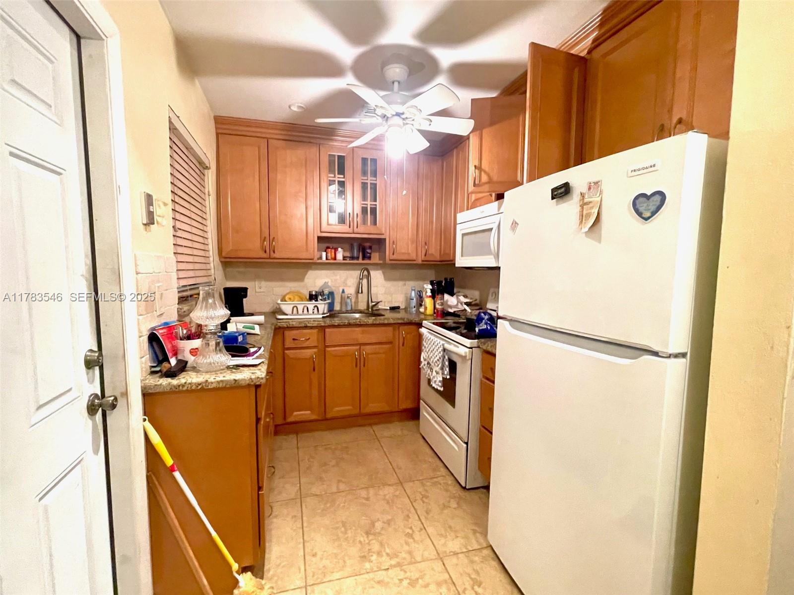 5455 Southwest 116th Avenue Miami, FL 33165 - Photo 4 of 18 a kitchen with a refrigerator a sink dishwasher and a refrigerator with wooden floor