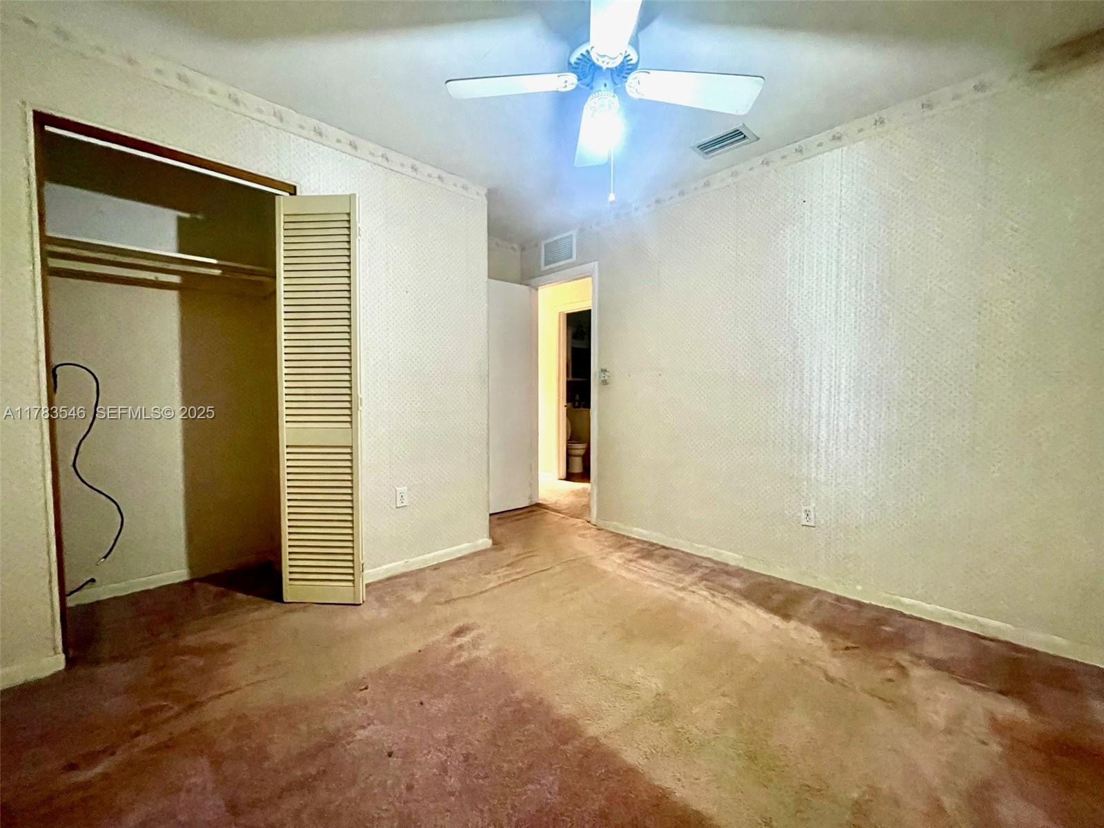 5455 Southwest 116th Avenue Miami, FL 33165 - Photo 7 of 18 an empty room with closet and a chandelier fan
