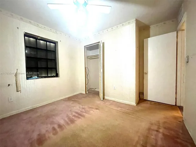 an empty room with windows and closet