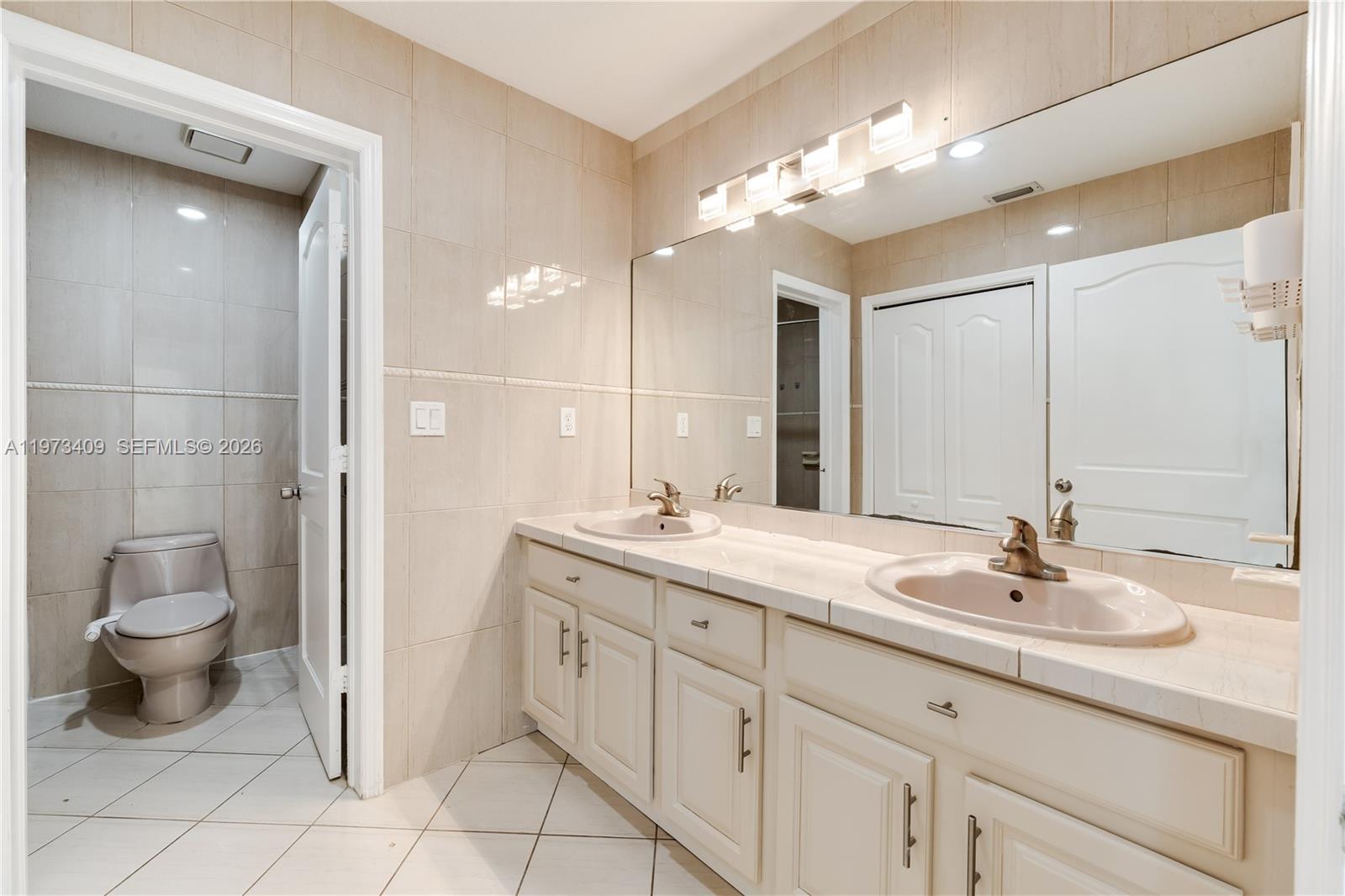 13050 Southwest 26th Street Miami, FL 33175 - Photo 17 of 43 a bathroom with a double vanity sink and a mirror