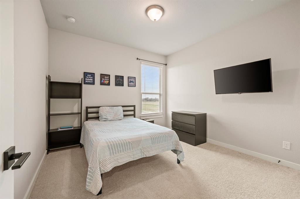 417 Ardsley Lane Forney, TX 75126 - Photo 24 of 31 a bedroom with a bed and a flat screen tv