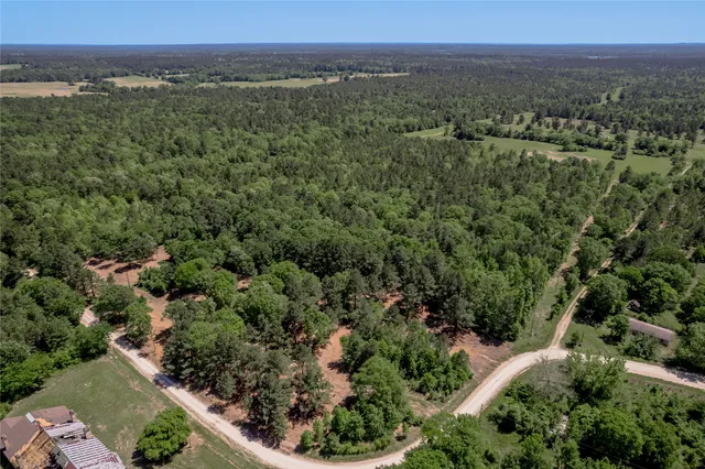 an aerial view of a houses with a yard and lake view