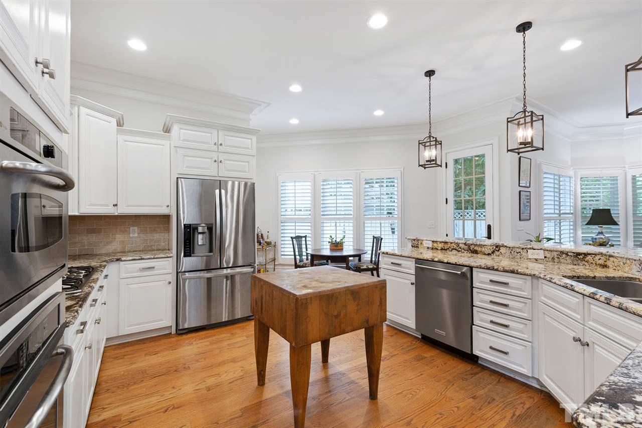 1907 McCarthy Street Raleigh, NC 27608 - Photo 11 of 30 a kitchen with stainless steel appliances granite countertop a sink stove and refrigerator