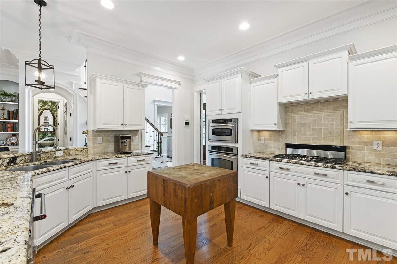 1907 McCarthy Street Raleigh, NC 27608 - Photo 9 of 30 a kitchen with a sink stove and white cabinets