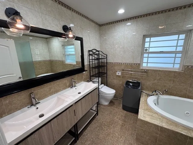 a bathroom with a double vanity sink a toilet and mirror