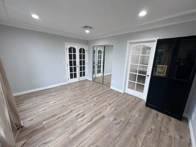 an empty room with wooden floor and closet