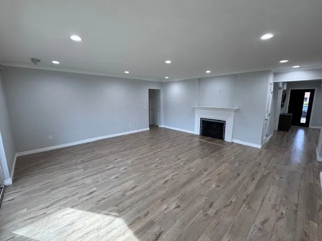 an empty room with wooden floor and fireplace