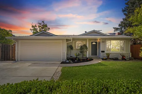 a front view of a house with a garden and yard
