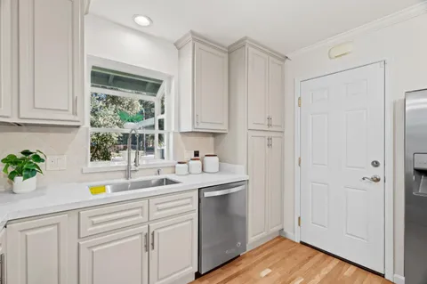 a kitchen with a sink a window and cabinets