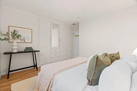 a bedroom with a bed and a painting on the wall