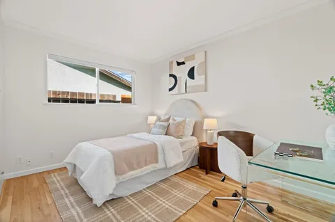 a bedroom with a bed and painting on the wall