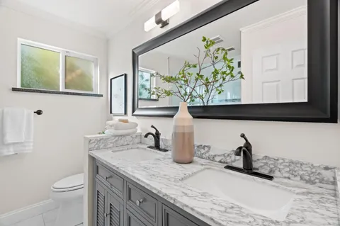 a bathroom with a granite countertop sink and a toilet