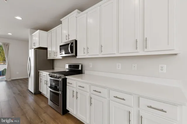 a kitchen with stainless steel appliances granite countertop a stove a sink and a refrigerator