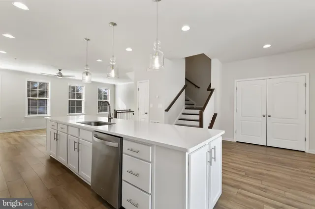 a kitchen with sink stove and wooden floor