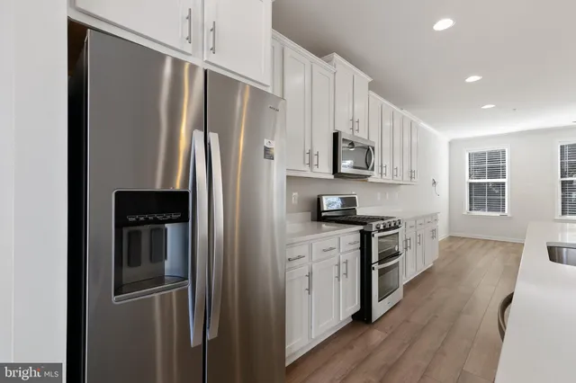 a kitchen with stainless steel appliances and refrigerator