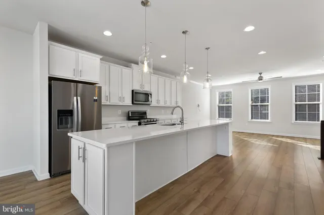 a kitchen with stainless steel appliances a refrigerator sink and microwave
