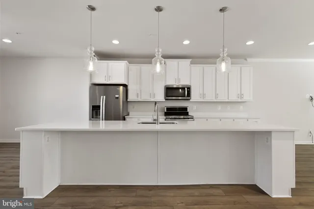 a kitchen with kitchen island white cabinets and refrigerator