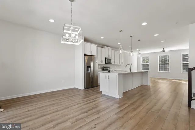 a view of kitchen with sink refrigerator and cabinets