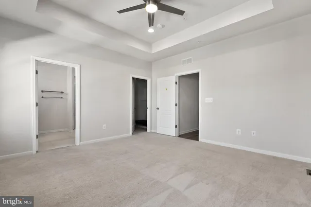 an empty room with fan and entrance