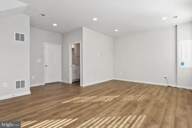 a view of an empty room with wooden floor