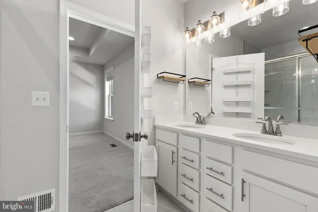 a bathroom with a double vanity sink mirror and shower