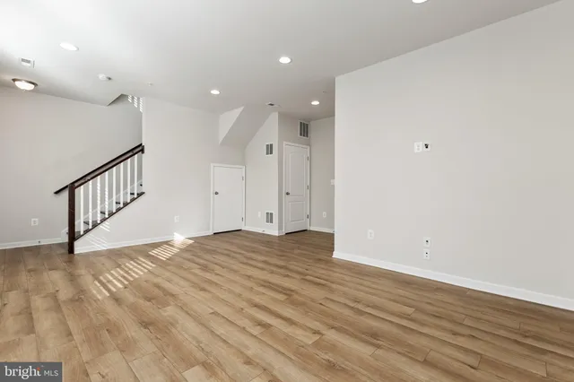 a view of an empty room with wooden floor