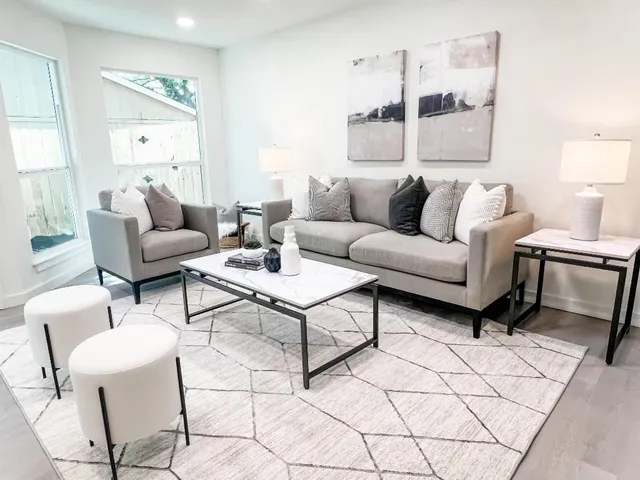 a living room with furniture and a wooden floor