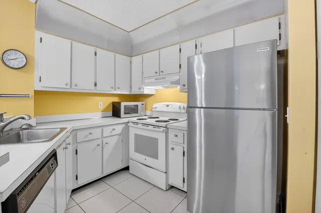 a kitchen with a refrigerator sink and cabinets